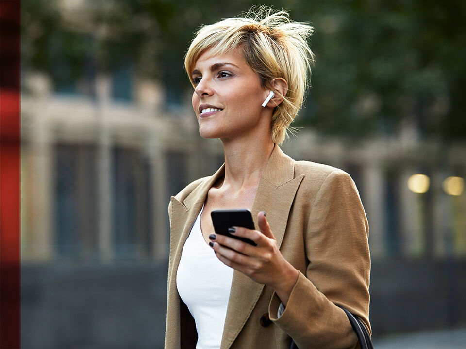 jeune femme darchant dans la rue avec smartphone